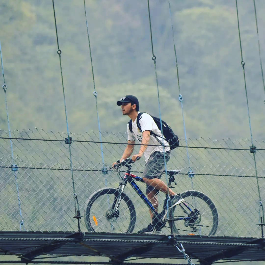 Guest from North Nepal Trek cycling in Suspension bridge in Pokhara